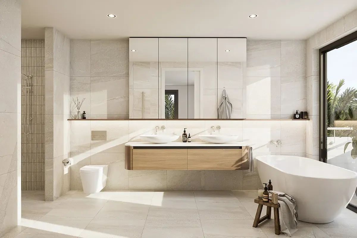An ensuite with a long timber vanity and twin basins, a freestanding bath alongside and glazing opening to planting outside.