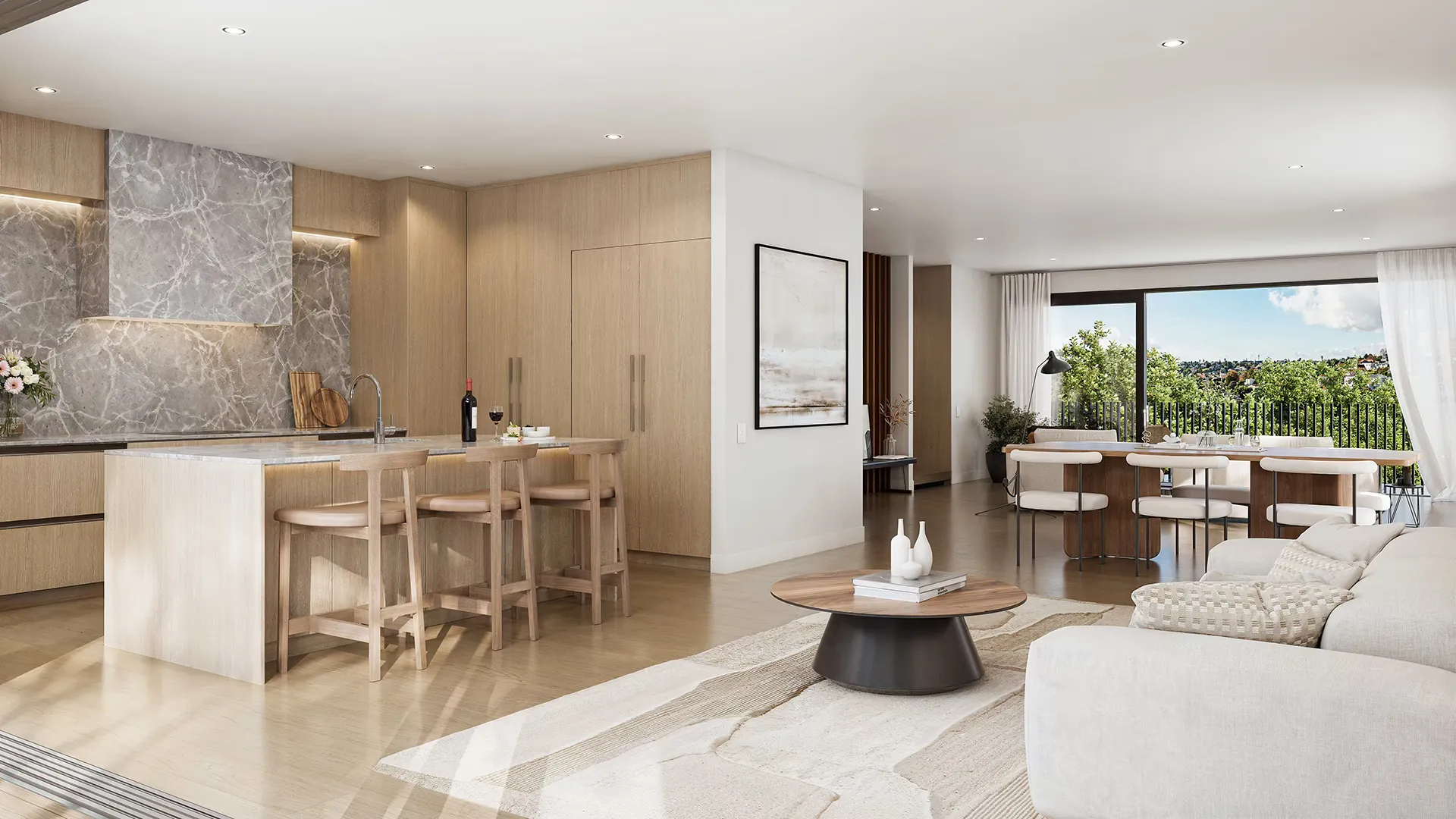 An open-plan kitchen, dining and living space with a stone island, pale timber joinery and full-height glazing to a garden outlook.